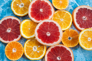grapefruit, orange and tangerine on a blue background. Citrus texture