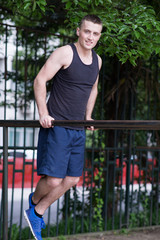 strong man doing pull-ups on a bar outdoor