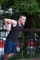 strong man doing pull-ups on a bar outdoor