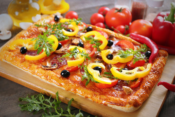 Rectangle delicious pizza and vegetables on the table, close-up