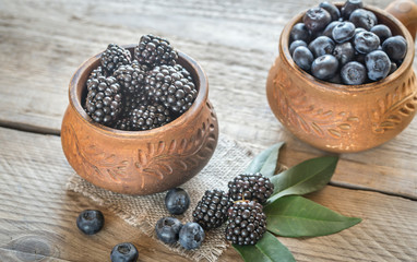 Fototapeta na wymiar Bowl of blackberries on the wooden table