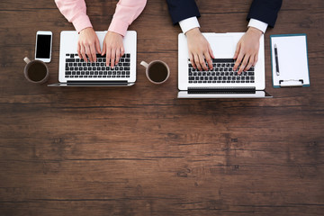 Man and woman working on laptops