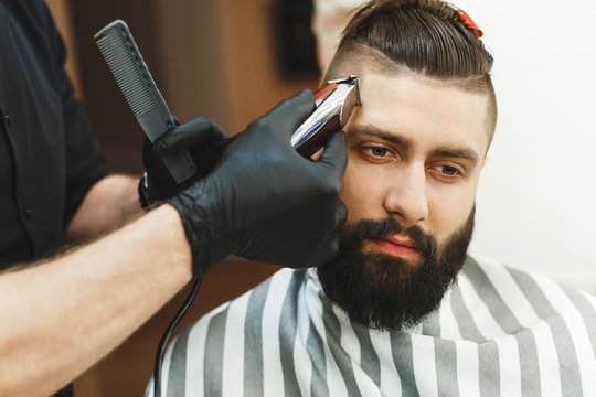 Man with dark hair doing a haircut