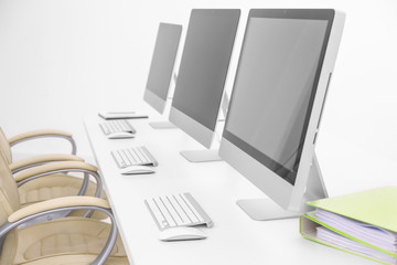 Modern computers on white wooden table in office