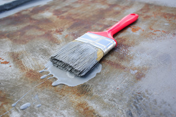 paint brush with paint on the rusty iron