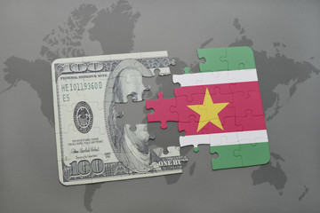 puzzle with the national flag of suriname and dollar banknote on a world map background.