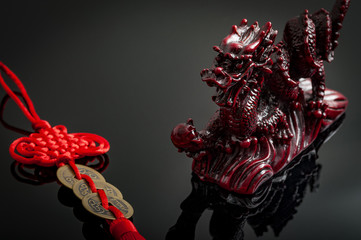 Naklejka premium Wealth and power symbolized by the fengshui coins charm and the asian mystic dragon. Feng Shui is a Chinese philosophical system of harmonizing everyone with the surrounding environment