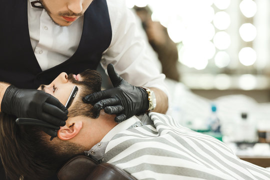 Hands in gloves making beard form