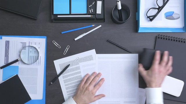Corporate businessman tidying up his messy desktop, efficiency and organization concept, top view