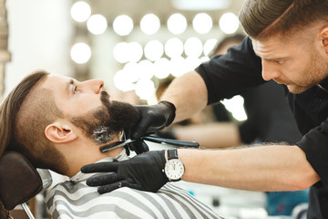Barber making beard form for man
