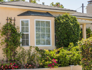 bay window surrounded by flowers and shrubs
