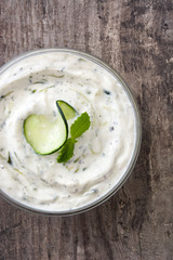 Tzatziki sauce in bowl on rustic wooden table

