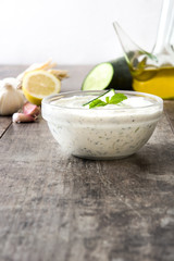 Tzatziki sauce in bowl on rustic wooden table
