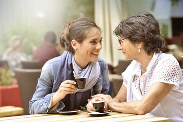 Senior woman with home carer having coffee together