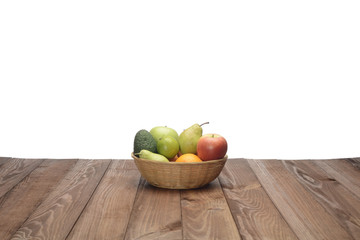Bodegón de frutas variadas en un canasto sobre fondo de madera