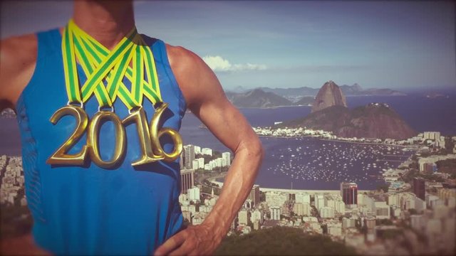 First place athlete wearing 2016 gold medals standing at a scenic overlook with Sugarloaf Mountain and Guanabara Bay in Rio de Janeiro, Brazil