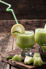 Fresh melon smoothie in the glass on the wooden table