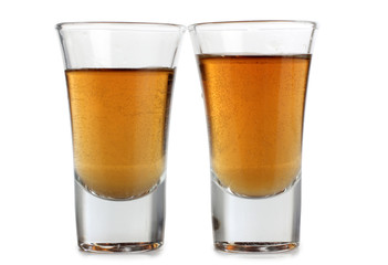 Glass jars with whiskey and ice on white background