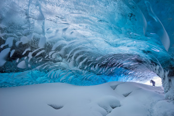 Hiker exploring ice cave, iceland