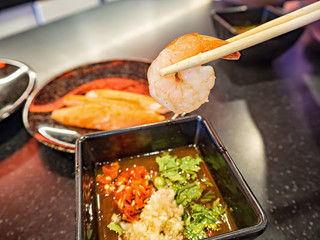 Chopsticks with shrimp over spicy sauce