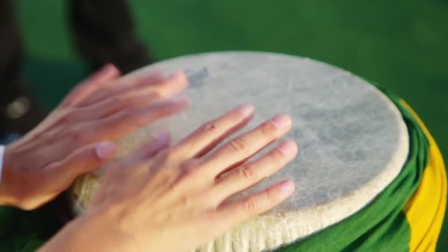 Rio Brazil Samba Carnival. Someone plays music on drum wrapped with Brazil flag. Hands only.