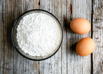Two eggs and a bowl of flour - baking cooking process