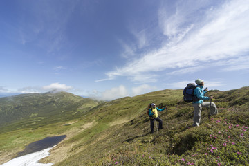 Fototapeta premium Summer hiking in the mountains with a backpack .