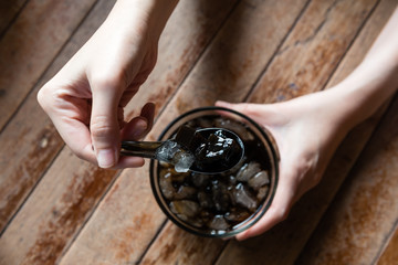 hand holding a spoonful of Chao kuai (asian grass jelly)