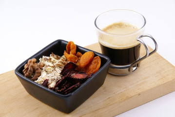 A healthy breakfast of oatmeal with nuts and dried fruits, complemented by freshly brewed coffee on white background