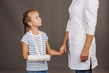 doctor pediatrician holds the hand of a  small girl patient 