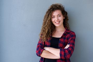 Smiling teenage girl standing with arms crossed
