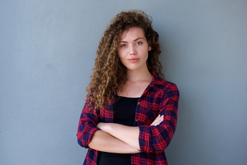 Confident teenage girl standing with arms crossed