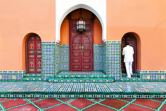 Moroccan building exterior with traditional tile, decorative paint and arched doors