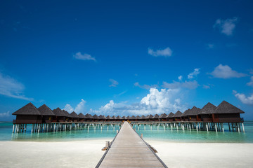 Fototapeta na wymiar Beautiful beach with water bungalows at Maldives