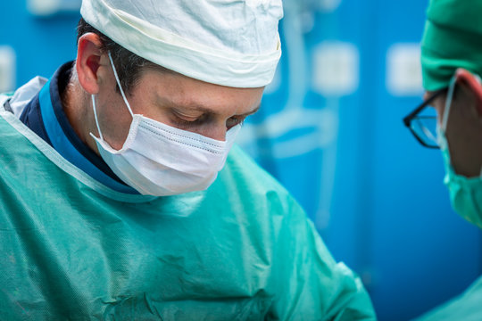 Orthopedic surgeon portrait while operating and focusing on his