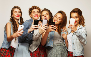 group of young women looking at their smartphones 