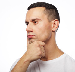 Obraz premium Portrait of handsome young thoughtful man isolated over white ba