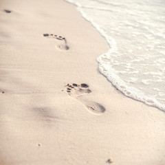 Soft focus and tone of footprints on the tropical beach sand wit