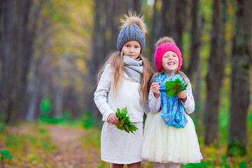 Little adorable girls outdoors at warm sunny autumn day