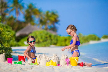 Little girls playing with beach toys during tropical vacation