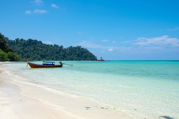 Long tail wooden boat anchor with csytal sea white sand at lipe island,andaman,thailand
