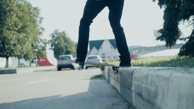 Skateboarder doing a skateboard tail board slide over the rail at the skate park.