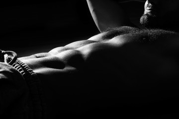 Young sports guy with a naked torso in the gym