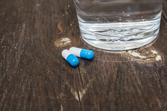 Pills capsules medicine and glass of water