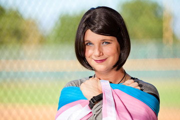 Transgender girl holding Trans Pride flag.