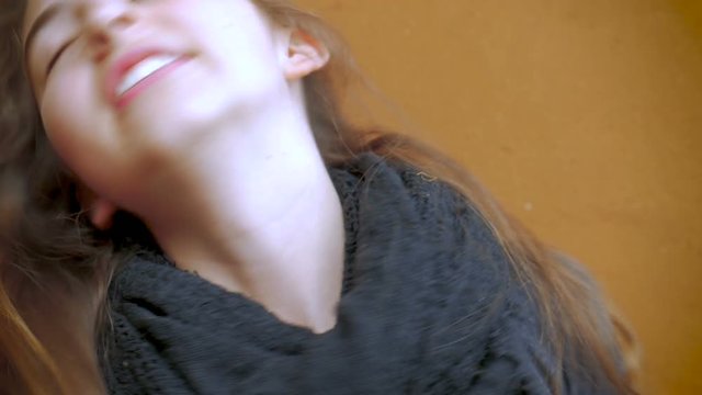 A beautiful young teenage girl twirls her hair and smiles in slow mo