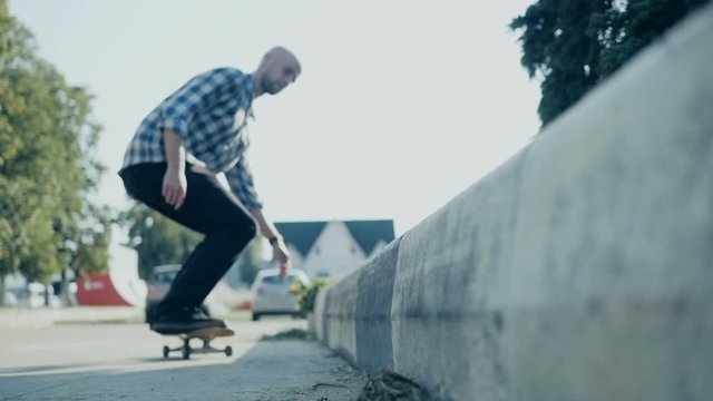 Skateboarder doing a skateboard tail board slide over the rail at the skate park.