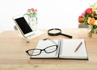 Open Blank notebook and pencil with magnifying glasses and