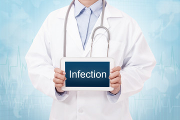 Doctor holding a tablet pc with infection sign on blue background