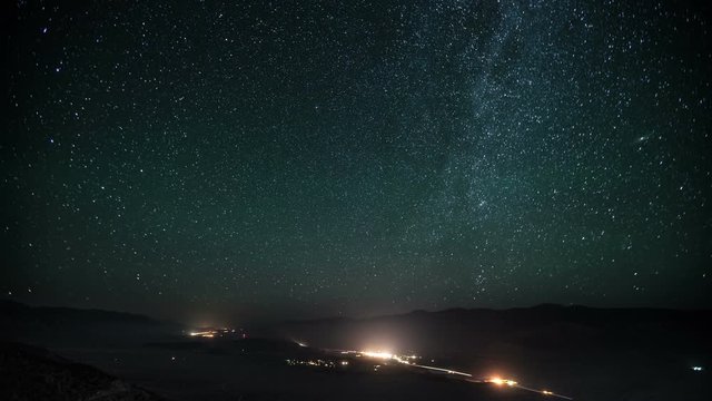 Time lapse of a road going the desert with the night sky moving above.